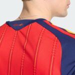 Back of a person wearing a red athletic jersey with blue shoulder panels and a silver chain necklace at the neck area.