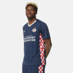 PSV Eindhoven navy football jersey with red-and-white checkered side panels and sponsor text Brainport Eindhoven.
