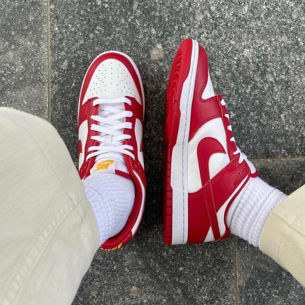 b1e84fac-c8a9-4bb6-bcb1-ba972d2a5282_39a1fddc-7c7b-414d-9da8-6f690d8b2754 | UAE SPORT STORE Person wearing red and white Nike sneakers with white socks standing on gray pavement.