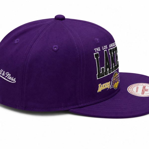 Purple Los Angeles Lakers snapback hat with white Mitchell & Ness script on the side and embroidered LA logo on the front.