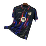 Black FC Barcelona jersey with blue and red brush strokes, Nike swoosh, Barça crest, and Spotify circular logo on the chest.