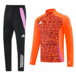 Black athletic pants with pink side panels paired with an orange leopard‑print long‑sleeve top with white stripes on the sleeves.