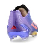 b44e1a7fbbe3 | UAE SPORT STORE Rear view of a purple Adidas turf shoe with orange stripes and a studded blue sole on a white background.