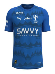 Blue football jersey featuring multiple sponsor logos (SAVVY GAMES GROUP) and team crest, front view with patterned design across the chest.