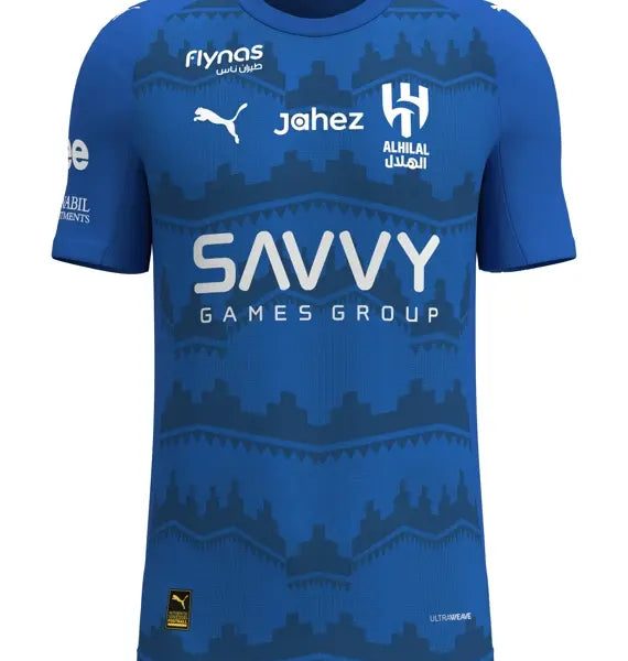 Blue football jersey featuring multiple sponsor logos (SAVVY GAMES GROUP) and team crest, front view with patterned design across the chest.