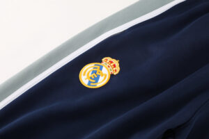 b5f610bb | UAE SPORT STORE Embroidered Real Madrid crest on navy blue jacket fabric with a white trim stripe.