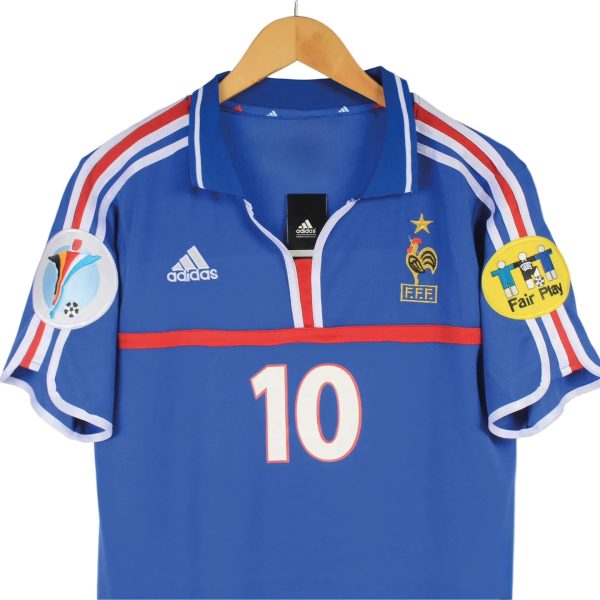 Blue France national soccer jersey on a hanger, with red stripe, gold crest, and the number 10 on the front.
