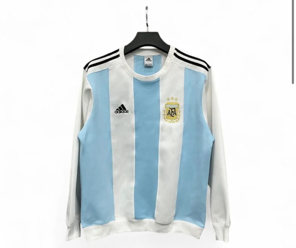 Argentina national team jersey on a hanger, white and sky blue vertical stripes with AFA crest and three stars