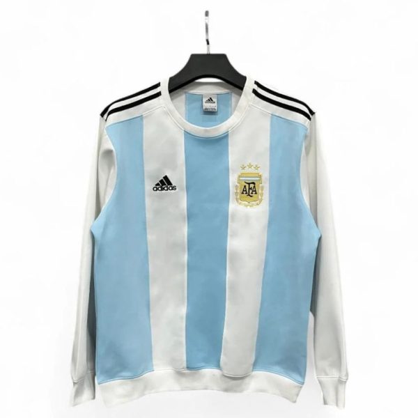 Argentina national team jersey on a hanger, white and sky blue vertical stripes with AFA crest and three stars