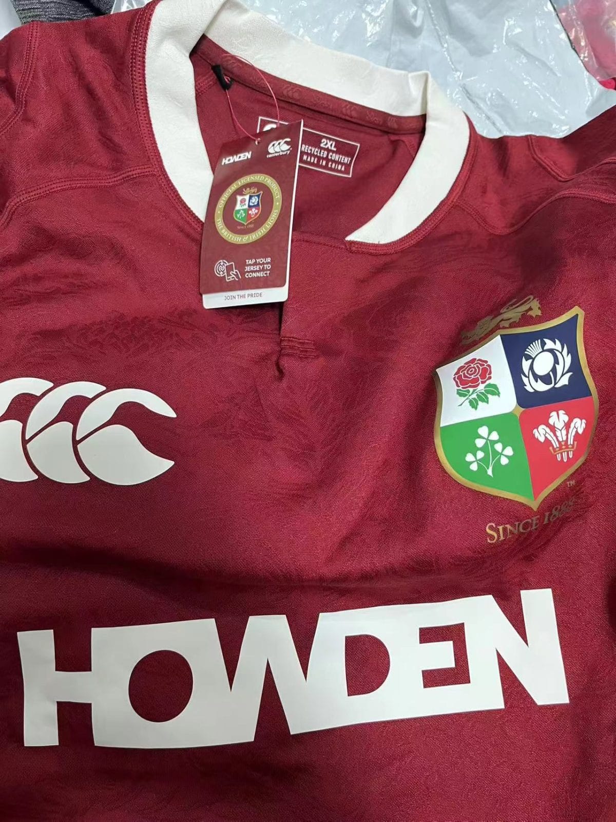 Maroon rugby jersey with white collar and crest on the left chest; tag attached.