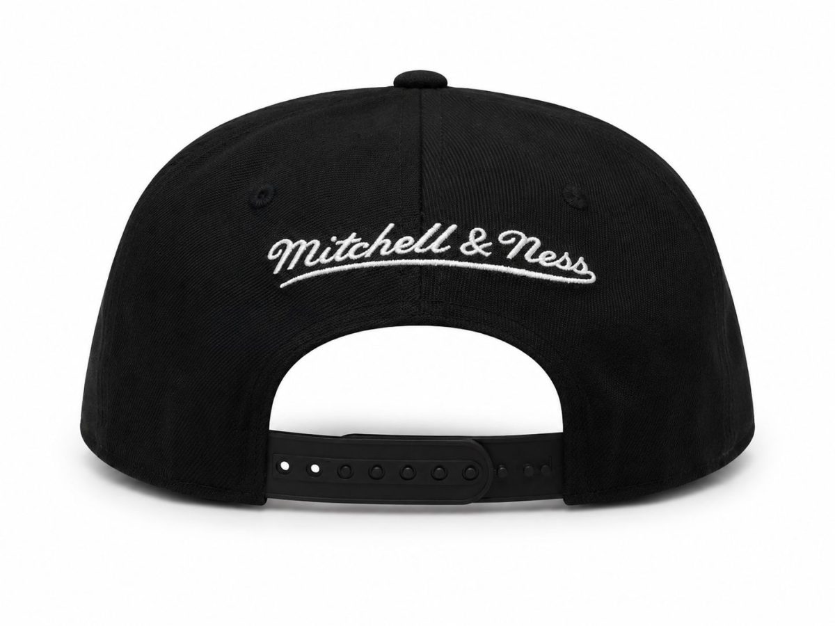 Back view of a black adjustable baseball cap with white embroidered 'Mitchell & Ness' logo on the rear panel and a plastic strap closure.