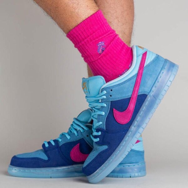 Blue and light-blue high-top sneakers with a hot-pink emblem, worn with bright pink socks visible above the shoes.