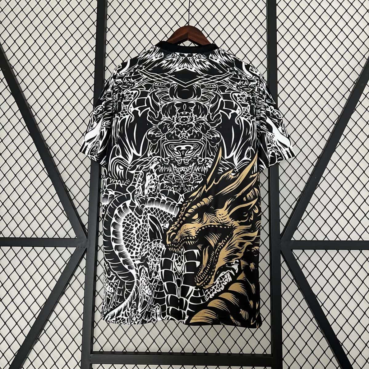 Black-and-white shirt on a wooden hanger featuring intricate dragon and tiger graphic against a metal lattice backdrop.