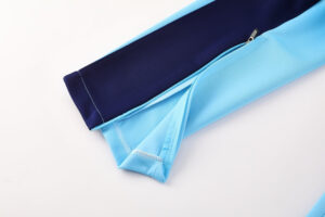 b85e797a | UAE SPORT STORE Close-up of a two-tone blue sleeve (light blue and navy) with a zipper and visible stitching detail.