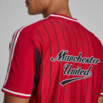 Back view of a red Manchester United soccer jersey with black pinstripes and white trim on the shoulders and collar.