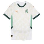 White soccer jersey with mint green side panels, dark green sleeve cuffs, and orange Puma logos on chest and sleeves; features a green club crest with three stars on the left chest.