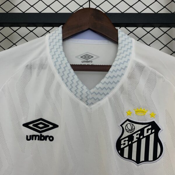 White striped sports jersey on a hanger, showing a blue zigzag-trim collar and the Umbro logo; crest with stars is partially visible on the right side.