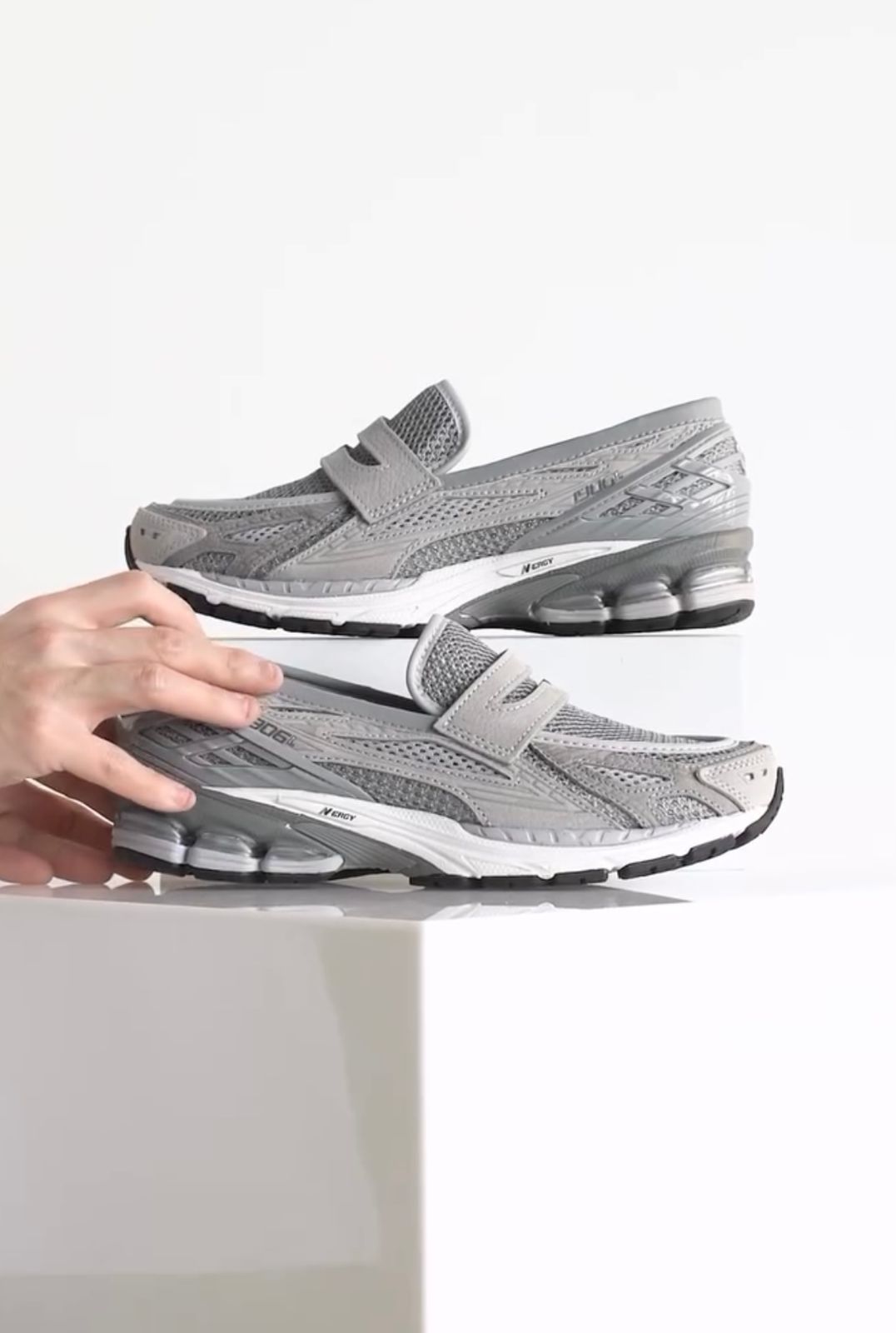b9b359ae-a989-48c9-b040-0a82b3a90ec2 | UAE SPORT STORE Pair of gray athletic sneakers with Velcro straps and visible cushioning, placed on a white surface.