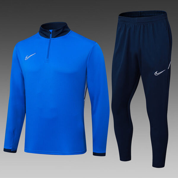 Bright blue Nike training top with a short zipper and dark collar, paired with navy Nike jogger pants featuring a white swoosh logo.