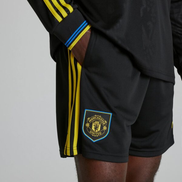 Black Manchester United shorts with yellow side stripes and club crest on the leg area
