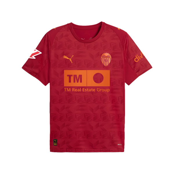 Valencia CF red jersey featuring an orange TM Real Estate Group sponsor logo across the chest, with the club crest and Puma swoosh visible on the chest patch.