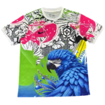 Colorful graphic T-shirt with a blue macaw, neon green shapes, and pink/black graffiti-style patterns including a Brazil crest.
