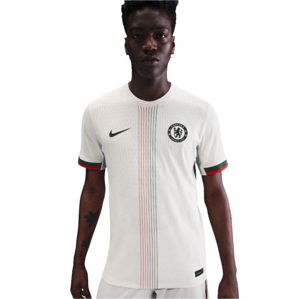 Man wearing a white Chelsea home jersey with green Nike swoosh and crest, standing facing camera.
