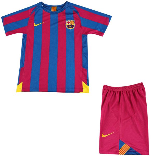 Barcelona football kit: blue and maroon striped jersey with crest and yellow Nike logo, paired with pink shorts featuring a yellow swoosh and color-blocked corner detail.