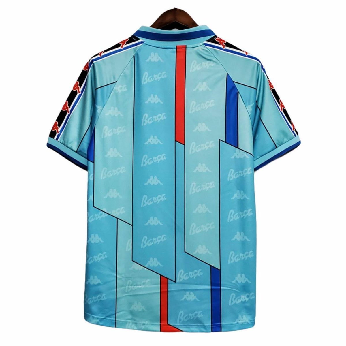 Back view of a turquoise Barcelona football jersey with geometric panels, Kappa logos, and red/blue vertical accents on sleeves and chest edge.