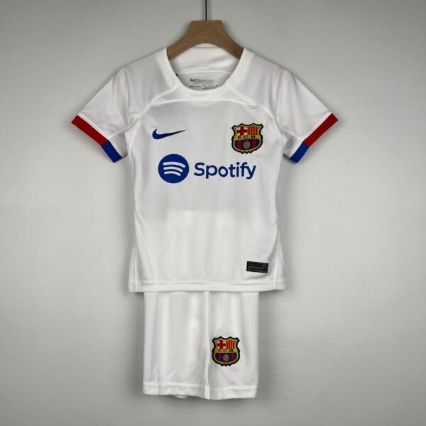 White FC Barcelona football jersey hanging on a wooden hanger, showing the club crest and Spotify sponsor logo on the front.