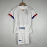 White polo on a wooden hanger with red-blue sleeve trim and a small UNHCR/ACNUR logo on the back hem area.