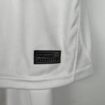 Close-up of light gray fabric with a black sewn label reading 'ENGINEERED' on the lower portion of the image.