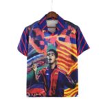 Colorful printed shirt on a wooden hanger, featuring a portrait and bold abstract patterns.