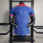 barcelona-special-edition-jersey-202324-239769 | UAE SPORT STORE Back view of a blue pixel-pattern athletic jersey on a black mannequin with red collar and red-trimmed sleeves in a retail display.