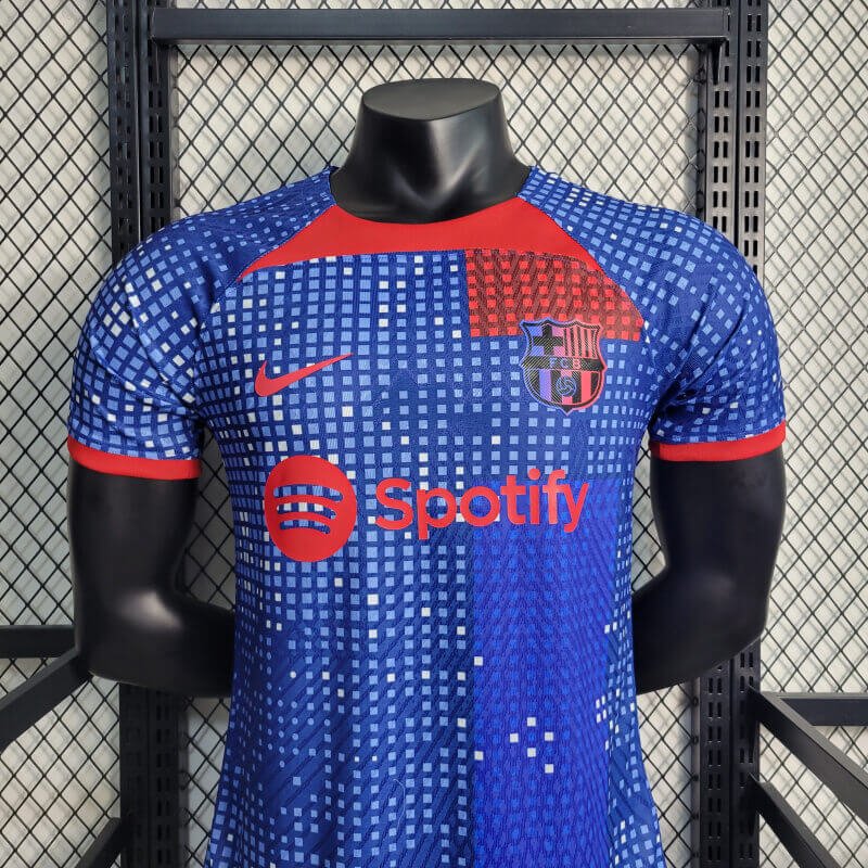 barcelona-special-edition-jersey-202324-350846 | UAE SPORT STORE Blue FC Barcelona soccer jersey with Spotify sponsor on a black mannequin in a showroom/display setting, red accents visible around the collar and sleeves, crest on chest.