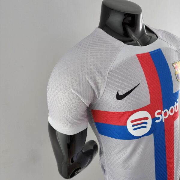 Mannequin wearing a light gray sports jersey with red and blue vertical stripes and a crest on the chest; only upper body visible.