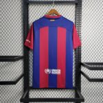 barcelona-x-karol-jersey-202425-176145 | UAE SPORT STORE Back view of a blue and maroon striped sports jersey hanging on a hanger with UNHCR branding visible on the lower back area.