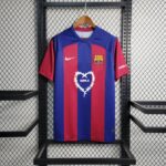 barcelona-x-karol-jersey-202425-469707 | UAE SPORT STORE Barcelona-style soccer jersey hanging on a wooden hanger against a metal rack, blue and red stripes with a team crest on the chest.