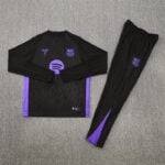 Black FC Barcelona training top and pants with purple accents laid on gray carpet, shown flat.