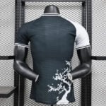 Back view of a headless mannequin wearing a dark teal athletic jersey with white sleeve cuffs and a white tree graphic along the lower right side.