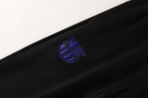 Close-up of black fabric with a blue embroidered shield crest.