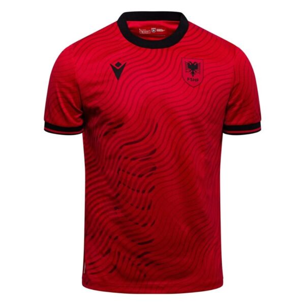 Red football jersey with black wavy pattern, black collar, Albanian Football Association crest on left chest and a black MACRON logo on the right chest