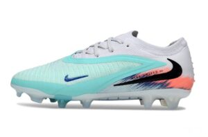 Turquoise and white Nike soccer cleat with a blue swoosh and orange gradient near the heel, studded outsole visible.