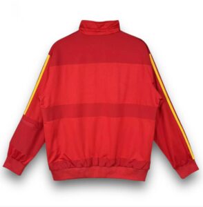 Back view of a red windbreaker with horizontal color blocks and yellow stripe along each sleeve.