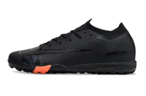 be638f92 | UAE SPORT STORE Black Nike Mercurial soccer cleat with an orange heel accent and textured upper, shown side profile.