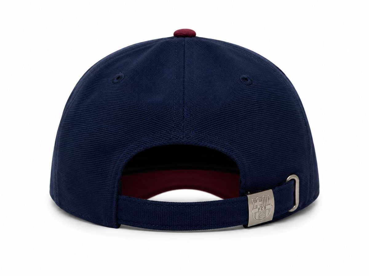 Navy baseball cap shown from the back with an adjustable strap and metal buckle featuring a crest logo.