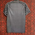 Back view of a dark gray polo shirt with a repeating white circular floral pattern and white sleeve trim.