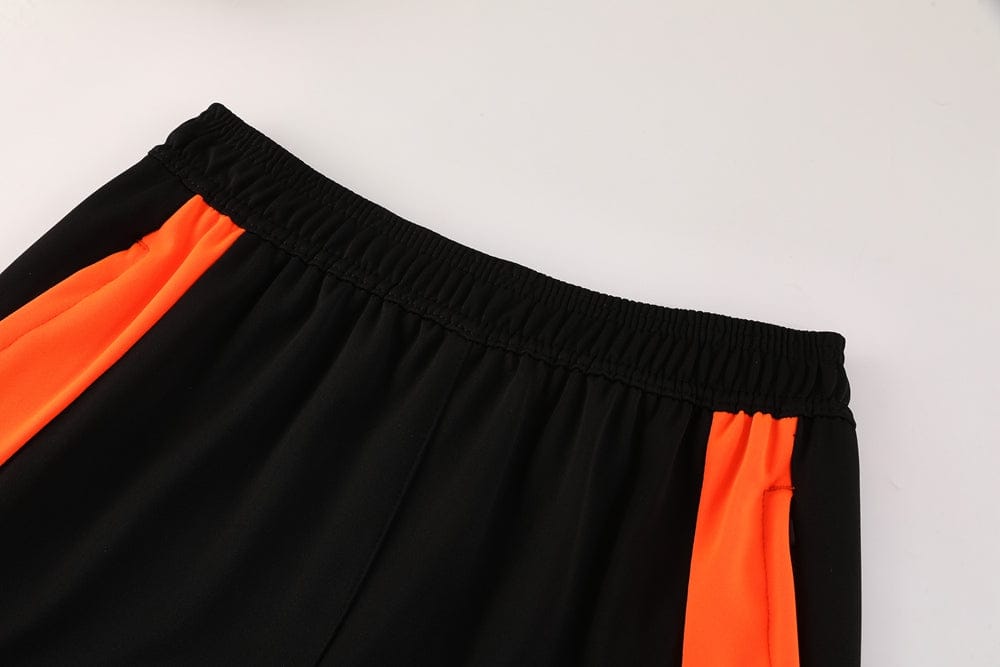 bfd0f916 | UAE SPORT STORE Black athletic shorts with bright orange side panels and an elastic waistband photographed on a light background.