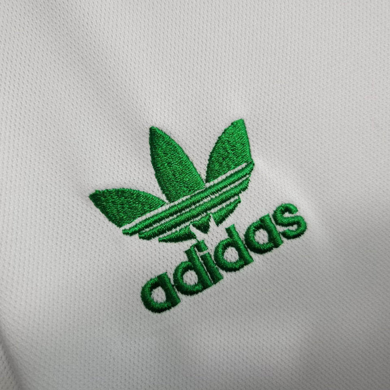 big-139_53d776a2-972c-49ef-b645-5e460cc2bfa1 | UAE SPORT STORE Green Adidas trefoil logo embroidered on white fabric.