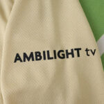 Beige textured fabric with black text reading 'AMBILIGHT tv'.